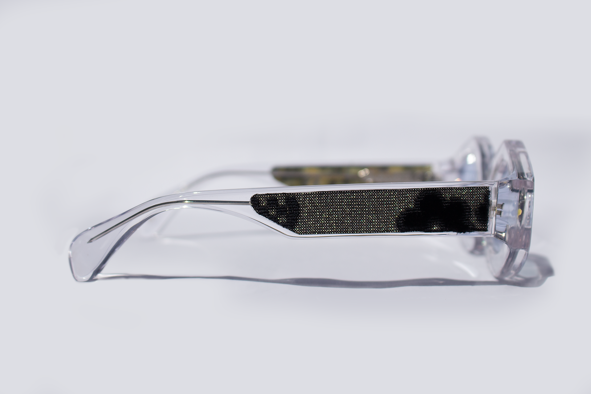 Dettaglio asta laterale occhiali da sole Maggio, elegante, asimmetrico statement in acetato cristallo trasparenti con inserto velluto fiorentino