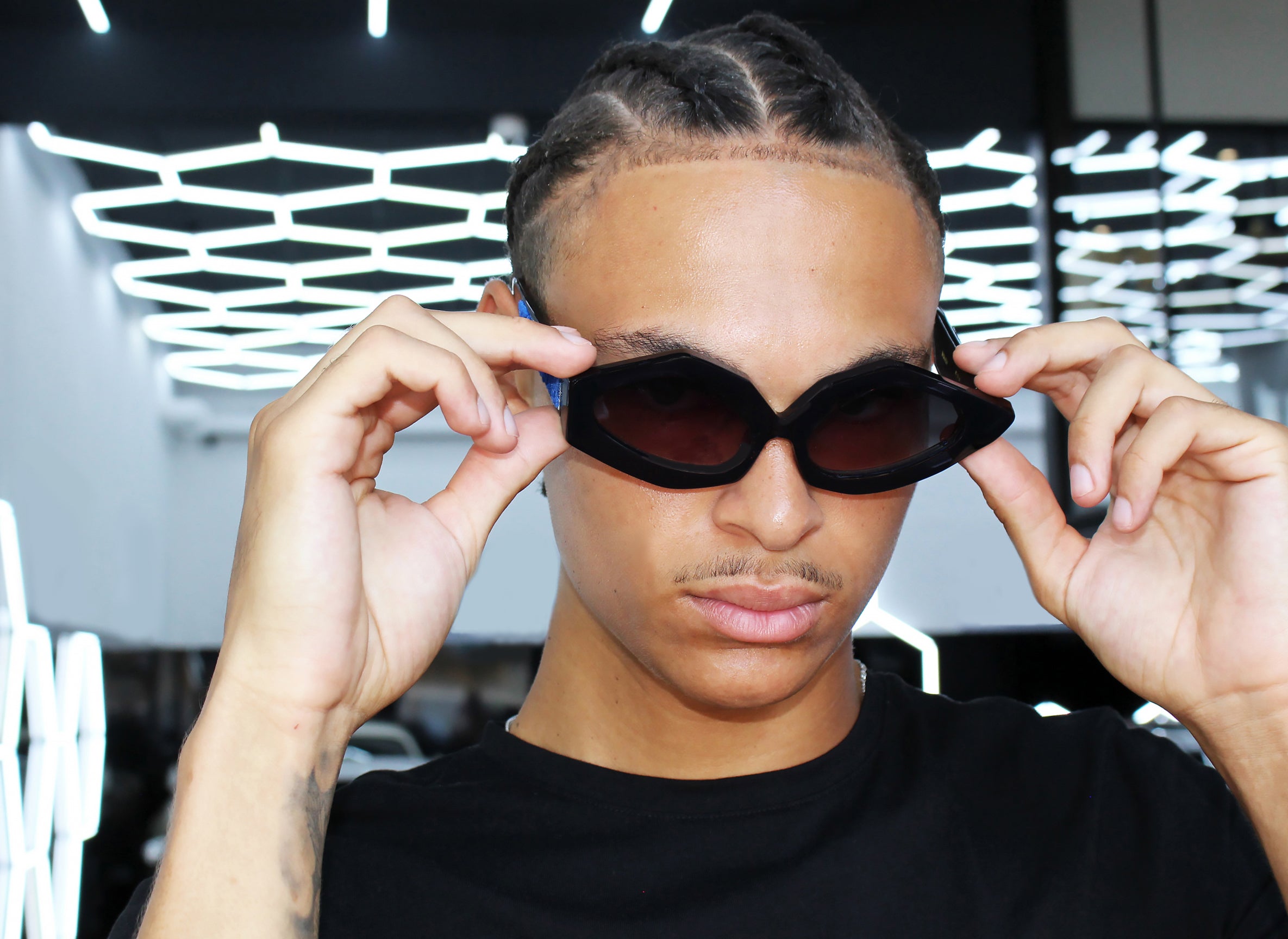 Modello indossa occhiali da sole Maggio, elegante, asimmetrico statement in acetato nero con inserto velluto fiorentino