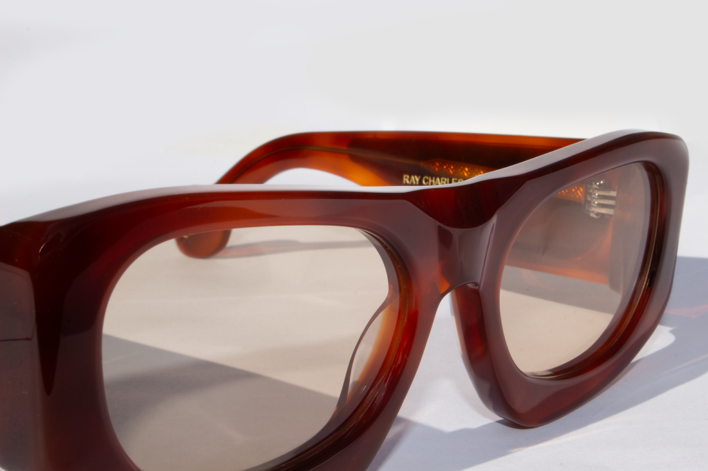 Dettaglio frontale occhiali da sole Ray Charles in acetato marrone artigianale italiano, inserto velluto fiorentino montatura avvolgente elegante design contemporaneo