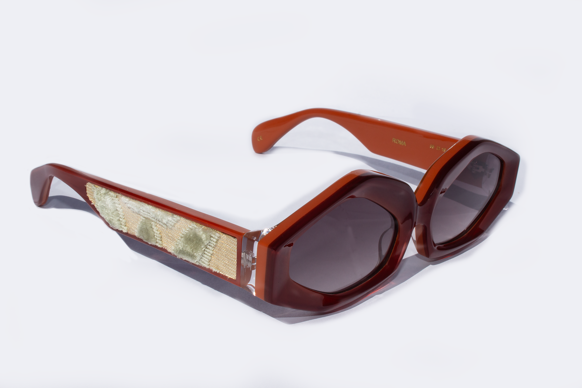 Vista laterale occhiali da sole Roma, elegante, statement in acetato rosso e caco con inserto velluto fiorentino