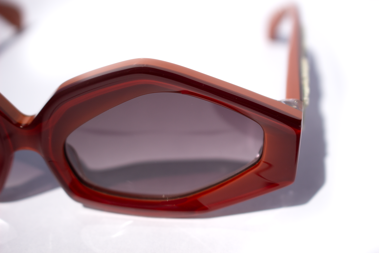 Dettaglio frontale occhiali da sole Roma, elegante, statement in acetato rosso e caco con inserto velluto fiorentino